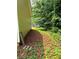 Exterior view of the side of the home, with lush green foliage and mature trees at 6103 Chaseland Dr, Rex, GA 30273