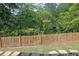 View of the backyard showcasing a wooden fence and picturesque greenery and pond in background at 783 Phil Haven Ln, Kennesaw, GA 30152