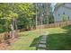View of the home's private backyard with lawn, trees, and stepping stones leading to fence at 783 Phil Haven Ln, Kennesaw, GA 30152