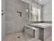 Bathroom with gray tiled walk-in shower and separate soaking tub under a window with natural light at 783 Phil Haven Ln, Kennesaw, GA 30152
