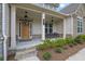 Inviting front porch with seating, stone steps, and stylish lighting at front door entrance at 783 Phil Haven Ln, Kennesaw, GA 30152