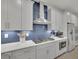 Gourmet kitchen with blue tile backsplash, white countertops, and stainless steel appliances at 783 Phil Haven Ln, Kennesaw, GA 30152