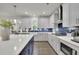 Bright kitchen features stainless steel appliances, white cabinets, an island with navy cabinets and quartz countertop at 783 Phil Haven Ln, Kennesaw, GA 30152