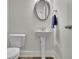 Elegant powder room features a pedestal sink, oval mirror, toilet, and neutral-toned walls at 783 Phil Haven Ln, Kennesaw, GA 30152