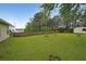 A spacious backyard with a shed, wooden fence, green grass, and mature trees at 2374 Brandenberry Ct, Decatur, GA 30034