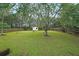 A spacious backyard with a shed, wooden fence, green grass, and mature trees at 2374 Brandenberry Ct, Decatur, GA 30034