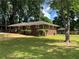 Charming brick home with a well-maintained front yard and mature trees at 4925 Sugar Valley Sw Rd, Mableton, GA 30126