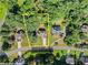 Aerial view of a home and property surrounded by lush greenery and mature trees at 7615 Abbey Glen Dr, Cumming, GA 30028