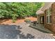Backyard with gravel, patio, grill, and wooded hill views at 7615 Abbey Glen Dr, Cumming, GA 30028