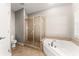 Bathroom with walk-in shower, soaking tub, and tile flooring at 7615 Abbey Glen Dr, Cumming, GA 30028