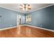 A spacious bedroom offers hardwood floors, blue walls, and natural light at 7615 Abbey Glen Dr, Cumming, GA 30028