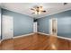 Large bedroom with blue walls, hardwood floors, and a ceiling fan at 7615 Abbey Glen Dr, Cumming, GA 30028