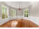 Charming dining room with large windows, hardwood floors, and stylish chandelier at 7615 Abbey Glen Dr, Cumming, GA 30028
