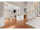 Inviting living area featuring hardwood floors, stone fireplace, and an adjacent staircase at 7615 Abbey Glen Dr, Cumming, GA 30028