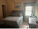 A bedroom featuring a queen bed, light neutral walls, a window, and a desk at 1128 Carillon Dr, Conyers, GA 30013