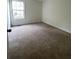 A bedroom with neutral carpet and walls, featuring a large window at 2915 Camelot Woods Dr, Lawrenceville, GA 30044