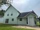 Back side view of home with muted green siding, dark roof, and a patio area at 2915 Camelot Woods Dr, Lawrenceville, GA 30044