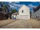 Rear view of a gray two-story home with an attached garage and a long concrete driveway at 5114 Arnold St, Covington, GA 30014