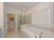 Modern bathroom featuring a glass-enclosed shower, soaking tub, and window for natural light at 3195 Bartee Walk, Suwanee, GA 30024