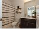 Well-lit bathroom featuring a shower with a decorative curtain and open shelving at 3195 Bartee Walk, Suwanee, GA 30024