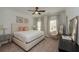 Well-lit bedroom with neutral tones, featuring a king-sized bed, ceiling fan, and stylish decor at 3195 Bartee Walk, Suwanee, GA 30024
