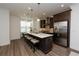 Modern kitchen with stainless steel appliances, granite countertops, dark cabinets, and a central island with barstool seating at 3195 Bartee Walk, Suwanee, GA 30024