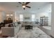 Spacious living room with a large sectional sofa, modern decor, ample natural light and a ceiling fan at 3195 Bartee Walk, Suwanee, GA 30024