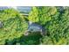 Aerial view of a home nestled among mature trees with a backyard patio and manicured lawn at 663 Clifton Ne Rd, Atlanta, GA 30307