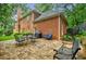 Brick house back patio featuring string lights, dining and lounging furniture, and a verdant lawn at 663 Clifton Ne Rd, Atlanta, GA 30307