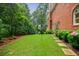 Spacious green backyard with a well-maintained lawn, garden beds, and the side of a brick house at 663 Clifton Ne Rd, Atlanta, GA 30307