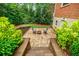 Lower patio with outdoor seating and greenery around steps of a brick home at 663 Clifton Ne Rd, Atlanta, GA 30307