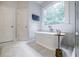Bathroom featuring a soaking tub, walk-in shower, and stylish tile flooring at 663 Clifton Ne Rd, Atlanta, GA 30307