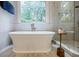 Bathroom featuring a soaking tub, walk-in shower, and backyard views at 663 Clifton Ne Rd, Atlanta, GA 30307