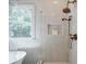 Stylish bathroom featuring a shower with bronze fixtures, a soaking tub and a window at 663 Clifton Ne Rd, Atlanta, GA 30307