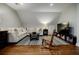 Hardwood floors and sloped ceilings define a cozy bonus room with modern furnishings and inviting seating options at 663 Clifton Ne Rd, Atlanta, GA 30307