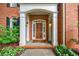 Inviting front porch with white columns and a wooden door, framed by lush landscaping and brick accents at 663 Clifton Ne Rd, Atlanta, GA 30307
