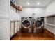 Well-lit laundry area features stainless steel washer and dryer, wood shelving and flooring at 663 Clifton Ne Rd, Atlanta, GA 30307