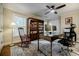 Well-lit home office with a ceiling fan, a large desk with two monitors, and a bookcase filled with books at 663 Clifton Ne Rd, Atlanta, GA 30307