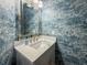 Powder room with designer wallpaper, marble countertop, and gold fixtures at 663 Clifton Ne Rd, Atlanta, GA 30307