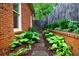 Brick-lined walkway beside a brick home, showcasing lush landscaping and manicured garden beds at 663 Clifton Ne Rd, Atlanta, GA 30307