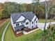 Aerial view of stunning modern farmhouse, lush landscaping, and private lot at 1387 Mineral Springs Rd, Hoschton, GA 30548