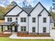 Charming two-story home featuring white siding, black trim, and a well-manicured front yard at 1387 Mineral Springs Rd, Hoschton, GA 30548