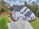 Beautiful home featuring modern garage doors, white siding, and meticulous landscaping at 1387 Mineral Springs Rd, Hoschton, GA 30548