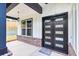 Stylish black front door with glass panes, complemented by brick accents and modern lighting at 1387 Mineral Springs Rd, Hoschton, GA 30548