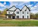 Elegant two-story home with a white exterior, black trim, and a well-maintained front yard at 1387 Mineral Springs Rd, Hoschton, GA 30548