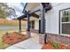 Charming front porch with brick columns and a manicured garden bed, enhancing curb appeal at 1387 Mineral Springs Rd, Hoschton, GA 30548
