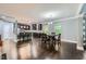 Open-concept dining room and kitchen boast dark hardwood floors, a breakfast bar and modern light fixtures at 5445 Whisper Ct, Cumming, GA 30028