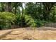Private backyard with mulch and gravel area, enclosed by a wooden fence and mature trees at 2876 White Oak Dr, Decatur, GA 30032