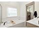 Bright bathroom showcasing a soaking tub, tiled walls, and open shelving at 2876 White Oak Dr, Decatur, GA 30032