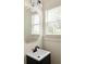 Stylish powder room with a sleek black vanity, decorative mirror, and natural light from the window at 2876 White Oak Dr, Decatur, GA 30032